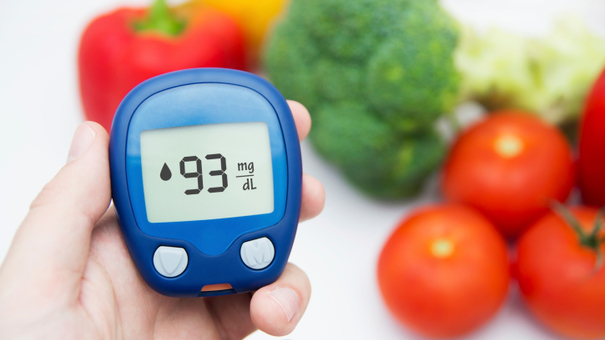 Diabetes doing glucose level test. Vegetables in background